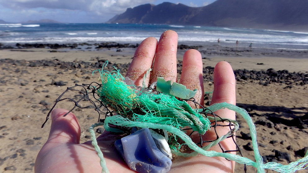 Recogida de plásticos en la playa (imagen de archivo)